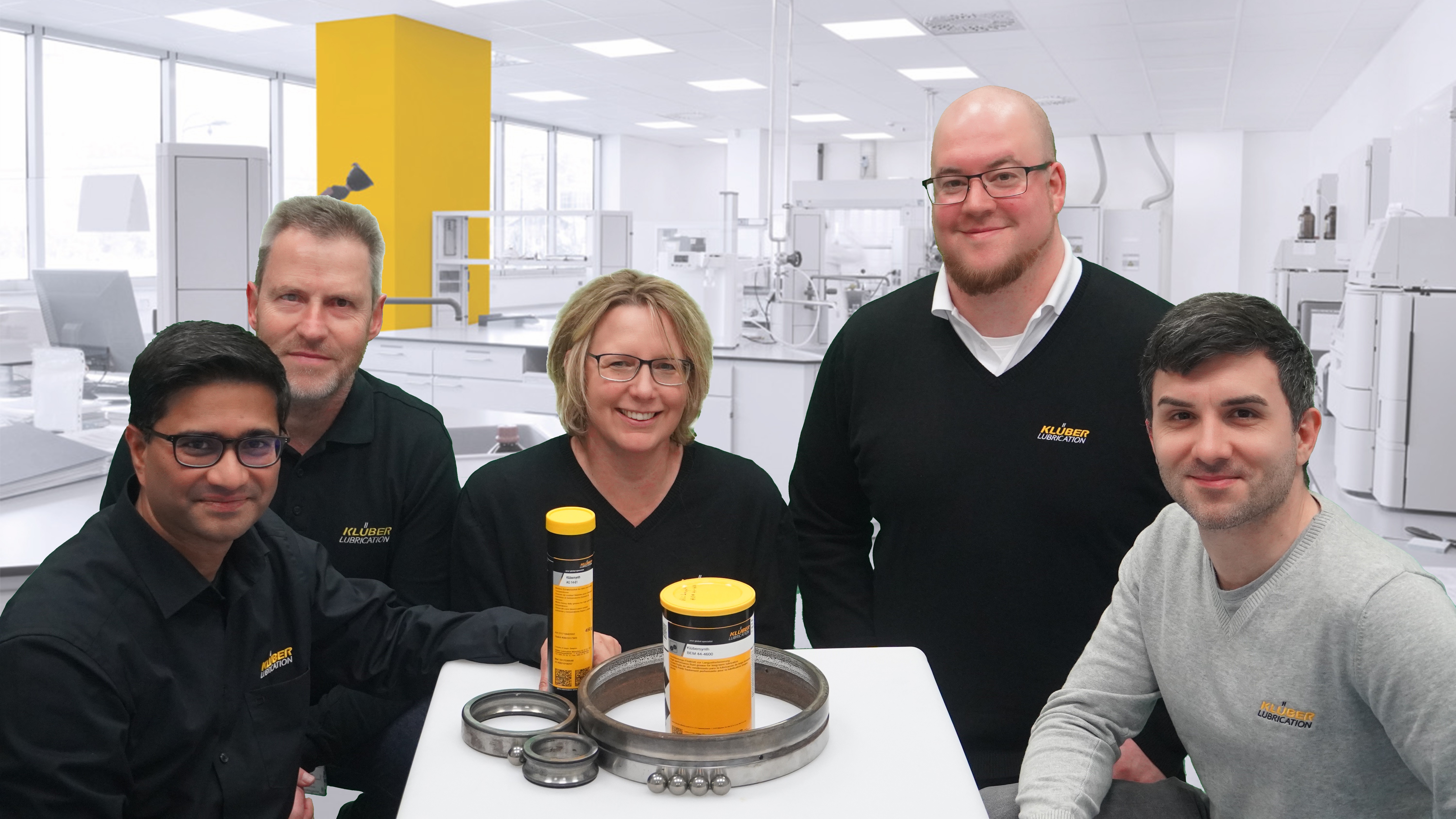 Five people smiling for a photo in a science lab