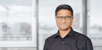 A photo of a smiling man wearing glasses