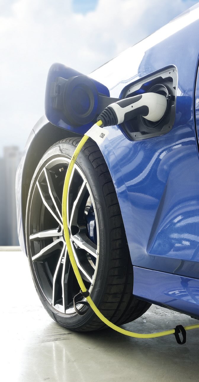 A blue electric vehicle plugged in for charging