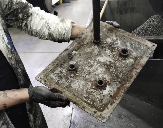 Contaminated filter plate removed during the overhaul process. Years of residue from cast iron machining and inadequate filtration led to rust, blockage and reduced coolant flow.