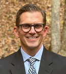 A smiling man with glasses.